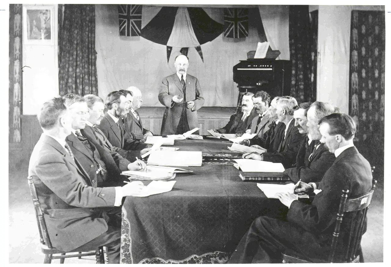 Men at a meeting around a long table, about 1910