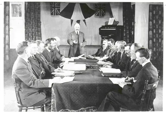 Men at a meeting around a long table